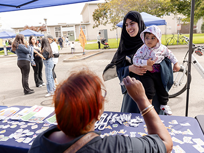Student holds child at booth